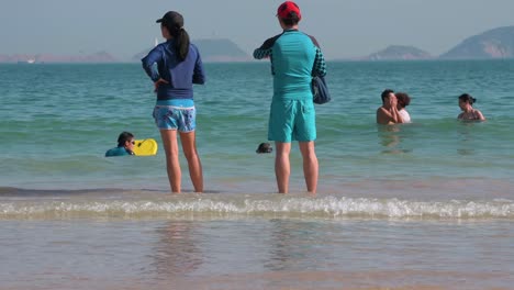 Gente-Nadando-En-El-Mar-En-La-Playa-De-Repulse-Bay-En-Hong-Kong-Mientras-Las-Playas-Públicas-Reabren-Al-Público,-Después-De-Meses-De-Cierre-En-Medio-Del-Brote-De-Coronavirus