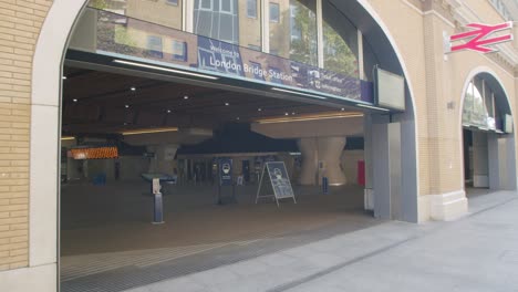 Lockdown-in-London,-Welcome-to-London-Bridge-Station-entrance-with-face-covering-signs-and-hand-sanitiser-station,-during-2020's-Coronavirus-pandemic