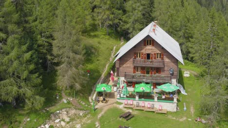 Scenic-aerial-view-of-mountain-hut-on-sunny-summer-day