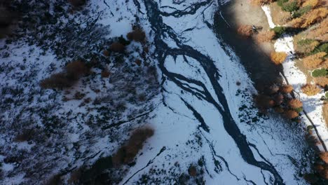 Ein-Blick-Aus-Der-Vogelperspektive-Auf-Einen-Kleinen-Fluss-Und-Gefrorenen-Boden