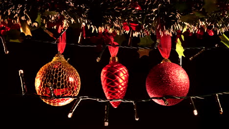 Weihnachtsdekorationskugel,-Die-An-Einer-Girlande-Und-Lichtern-Hängt,-Isoliert-Auf-Schwarzem-Hintergrund