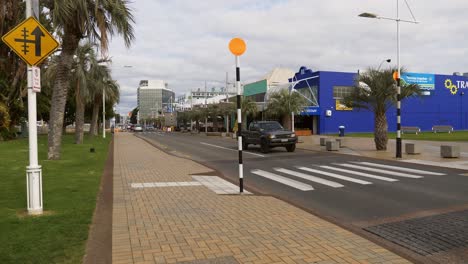 Pick-up-Auto-Fährt-In-Zeitlupe-Auf-Der-Asphaltstraße,-Vorbei-Am-Tradestaff-Gebäude-In-Tauranga,-Neuseeland-–-Langsamer-Schwenk