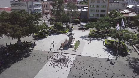 Una-Vista-Aérea-De-La-Plaza-Gerardo-Barrios-En-El-Centro-Histórico-De-La-Ciudad-Con-Gente-Alimentando-A-Las-Palomas.