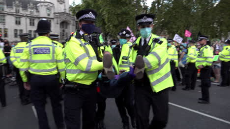 Oficiales-Metropolitanos-De-Londres-Llevan-Detenidos-A-Manifestantes-Por-El-Cambio-Climático-De-La-Rebelión-De-Extinción-A-Través-De-Líneas-De-Cordón-Policial-Durante-Las-Protestas-Frente-Al-Parlamento-En-Westminster-Durante-La-Pandemia-Del-Coronavirus