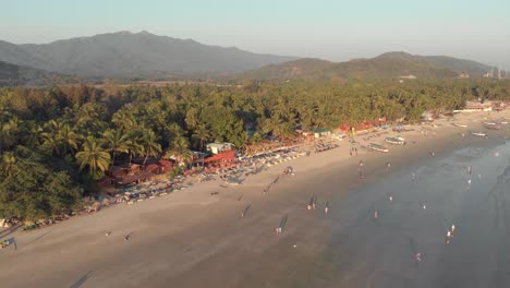 La-Gente-Pasea-Por-La-Arena-De-La-Playa-De-Palolem-Y-Las-Relajantes-Olas-Del-Mar,-Goa,-India