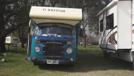 Gimbal-pan-right-shot-of-camper-van-parked-in-camping-area