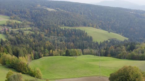 Luftschwenk-Direkt-über-Die-Landschaft-Mit-Sicht-Auf-Ein-Bauernhaus-Und-Eine-Scheune-In-Prevalje,-Slowenien
