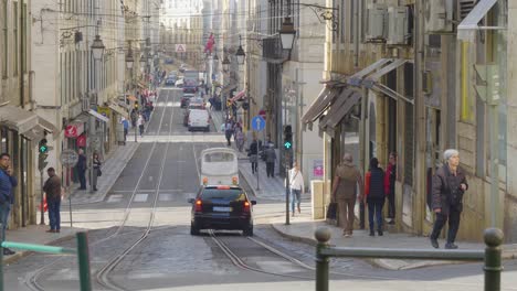 A-view-of-the-Lisbon-tram-moving-on-its-track-where-as-lots-of-tourists-visiting-the-old-city-of-Portugal