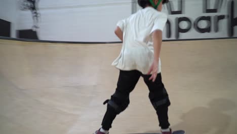 Un-Joven-Varón-Montando-Patineta-En-Una-Rampa-Dentro-Del-Parque-De-Patinaje-Cubierto-Con-Iluminación