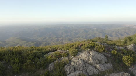 Hermosas-Colinas-Verdes-Que-Se-Extienden-Hasta-Donde-Alcanza-La-Vista,-Moviéndose-Hacia-Atrás-Para-Revelar-La-Cima-Rocosa-De-La-Hermosa-Montaña-En-Monchique,-Portugal