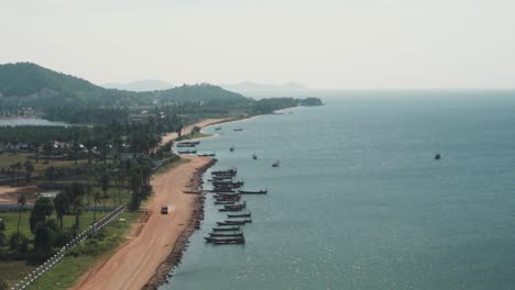 Asia-coast-line-with-parked-fishing-boats,-drone-fly-over