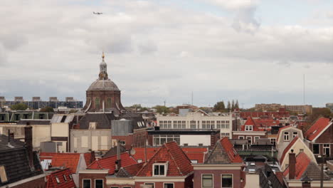 Old-town-of-Leiden-with-famous-Marekerk-Church-and-flying-airplane-at-sky