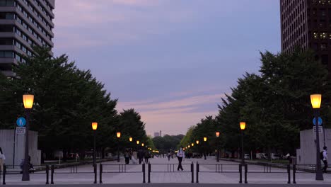 Totalaufnahme-Einer-Weiten,-Offenen-Gasse,-Annäherung-An-Den-Bahnhof-Tokio-In-Der-Abenddämmerung-Mit-Sonnenuntergangslicht-Und-Beleuchteten-Lampen