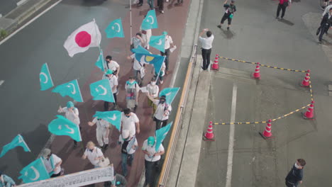 Demonstranten-Mit-Transparenten-Und-Ostturkestan-Und-Japanischer-Flagge-Marschieren-Nachts-In-Japan-Durch-Die-Straße-Von-Tokio