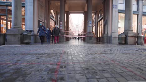 Low-angle-shot-of-people-with-face-mask-walking-in-Royal-Galleries-of-Saint-Hubert,-Brussels-during-coronavirus-pandemic