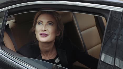 Businesswoman-Lowers-Window-Of-Black-Car-And-Looks-Up