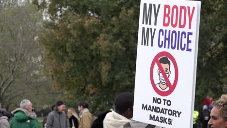 A-protest-placard-is-held-up-that-says,-“My-body,-my-choice,-no-to-mandatory-masks”-on-a-Coronavirus-and-QAnon-conspiracy-protest
