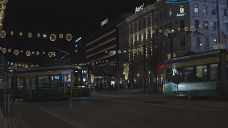 Drei-Straßenbahnen-Fahren-Nachts-Auf-Einer-Mit-Weihnachtsbeleuchtung-Geschmückten-Straße-Vorbei