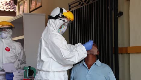 doctor-in-a-protective-suit-taking-a-nasal-swab-from-a-person-to-test-for-possible-coronavirus-infection