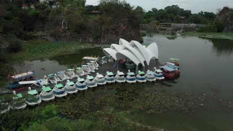 Fly-in-aerial-shot-of-Vietnamese-water-park-featuring-a-replica-miniature-Sydney-opera-house,-with-wharf,-and-paddle-boats