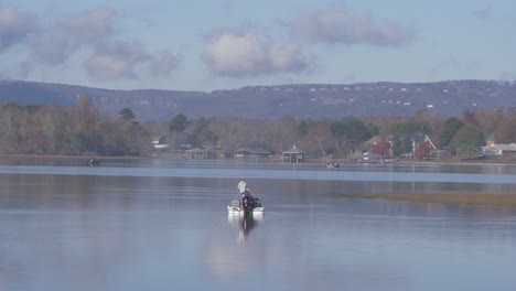 couple-fishing-on-lake-boats-in-background-slow-motion