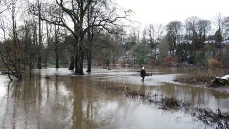 River-Bollin-in-Wilmslow,-Cheshire,-England,-UK-after-heavy-rainfall-and-bursting-its-banks-