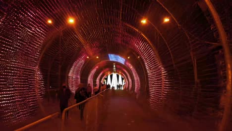 People-In-Face-Mask-Walking-Inside-Strobe-Light-Tunnel-Flashing-At-Night-During-Christmas-Season-In-Funchal-Amidst-Pandemic-In-Madeira,-Portugal