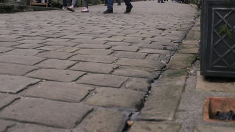 Shoppers-browsing-in-cobbled-street-in-Yorkshire-village-Haworth-low-shot