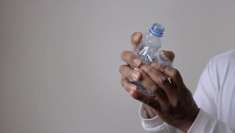 Hombre-Aplastando-Una-Botella-De-Plástico-Reciclada-Vacía-Antes-De-Reciclar-Almacen-De-Metraje-De-Video