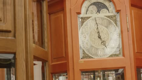 Large-wooden-grandfather-clocks-for-sale-with-man-in-reflection-at-Balvaria-market-in-Stuttgart,-Germany,-Baden-Wurttemberg-Europe