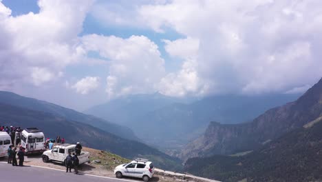 Low-Angle-Aufnahme-Von-Sonnigen-Wetterwolken-Und-Bergen-Mit-Touristen,-Die-Mit-Dem-Auto-Auf-Der-Straße-Von-Manali,-Indien-Stehen