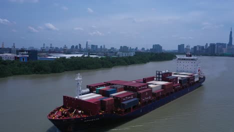 Vista-Panorámica-Aérea-De-Un-Gran-Barco-De-Contenedores-Que-Pasa-A-Lo-Largo-Del-Río-Saigon-En-La-Ciudad-De-Ho-Chi-Minh,-Vietnam-En-Un-Día-Soleado-Con-Un-Cielo-Azul-Claro-Y-Baja-Contaminación-Del-Aire