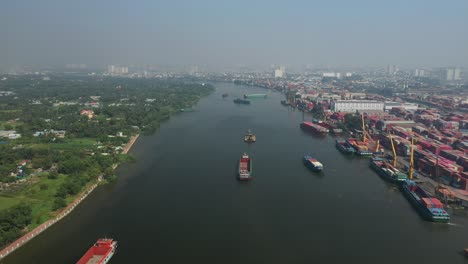 Drone-view-of-Saigon-River,-Ho-Chi-Minh-City-and-container-freight-terminal-on-a-sunny-day