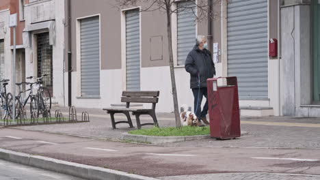 Ein-Alter-Mann-Trägt-Eine-Medizinische-Maske,-Während-Er-Mit-Seinem-Schönen-Hund-Durch-Die-Stadt-Geht