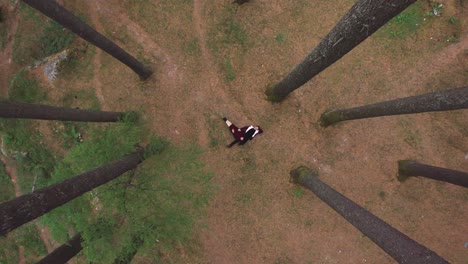 Aerial-top-down-shot-of-couple-lying-down-in-between-the-pine-trees