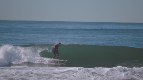 Ein-Surfer-In-Einem-Schwarzen-Neoprenanzug-Reitet-Auf-Einer-Welle-In-Der-Nähe-Von-Santa-Monica-–-Zeitlupe-Isoliert