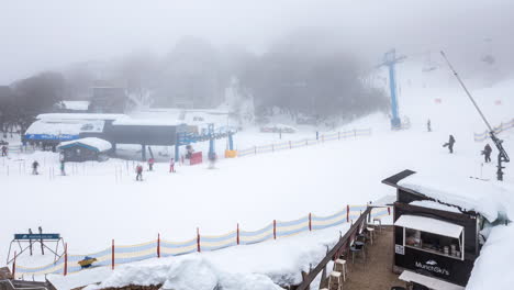 Skiers-and-snowboarders-coming-down-the-slopes-at-Falls-Creek-to-the-start-of-Halley's-Comet-chairlift,-in-time-lapse