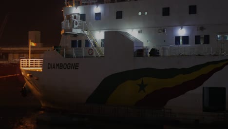 Pasando-Por-Barco-Senegalés-En-Vista-Nocturna,-Puerto-Autónomo-De-Dakar---Port-Autonome-De-Dakar