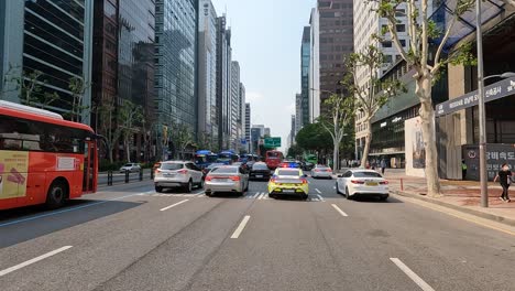 Tráfico-Conduciendo-En-Una-Calle-De-Cuatro-Carriles-Siguiendo-Un-Coche-De-Policía-En-Gangnam,-Seúl,-Corea-Del-Sur