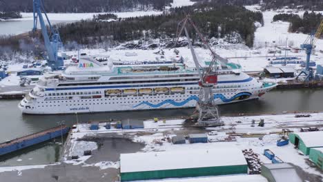 Kreuzfahrtschiff-Aidavita-Manövriert-Entlang-Der-Turku-Brlt-Reparaturwerft,-Unterstützt-Von-Alfons-Håkans&#39;-Schlepper-Dunker