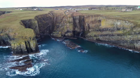 Drone-shot-of-the-cliffs-and-waterfall-at-Whaligoe-in-Scotland-UK