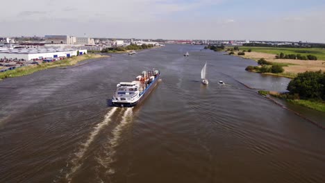 Vista-Aérea-De-Un-Buque-De-Carga-Que-Transporta-Contenedores-Intermodales-En-El-Río-Oude-Maas-En-Países-Bajos