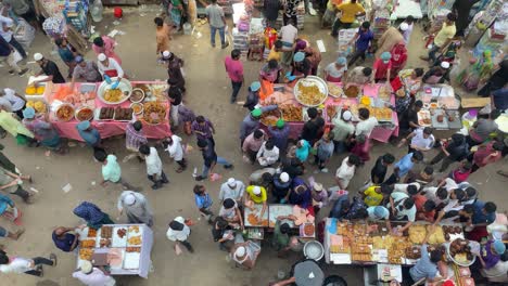 Small-colorful-counters-and-many-people-in-Old-Dhaka-street-market,-view-from-above