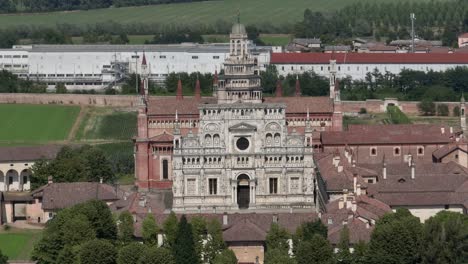 Aerial-view-of-the-Certosa-di-Pavia-at-sunny-day,-built-in-the-late-fourteenth-century,-courts-and-the-cloister-of-the-monastery-and-shrine-in-the-province-of-Pavia,-Lombardia,-Italy