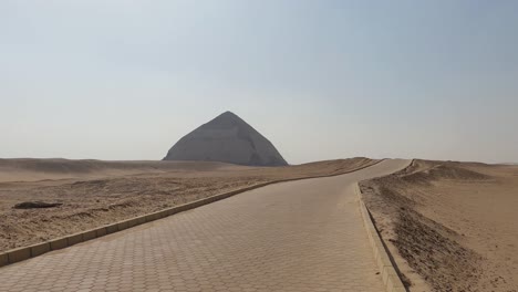 Sandy-Yellow-Desert-With-Ancient-Egyptian-Bent-Pyramid-On-The-Horizon,-Egypt