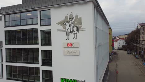 Antena-Acercándose-Al-Edificio-Con-El-Logo-De-La-Compañía-De-Abogados-Haakstad-Y-BRG---Edificio-De-Negocios-En-Friergangen-Street-Arenal-Noruega