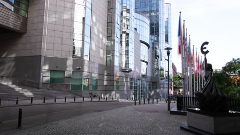 Zeitraffer-Von-Menschen,-Die-An-Einer-Statue-Mit-Einem-Euro-Symbol-Neben-Dem-Gebäude-Des-Europäischen-Parlaments-Vorbeigehen