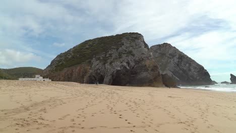 Cuevas-Gruta-Da-Adraga-Con-Playa-De-Arena-Llena-De-Huellas-De-Personas