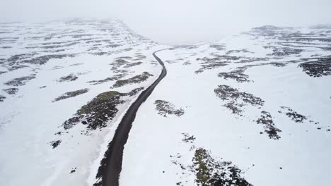 Road-surrounded-by-snow-and-endless-wilderness-on-Iceland's-beautiful-landscape