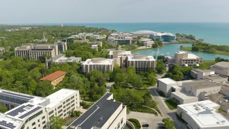 Drone-Flies-Above-Prestigious-Northwestern-University-on-Hot-Summer-Day-with-The-Lakefill-Fountain-Shooting-Water-Out